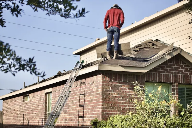 Professional roofer working on a residential roof in West Manchester